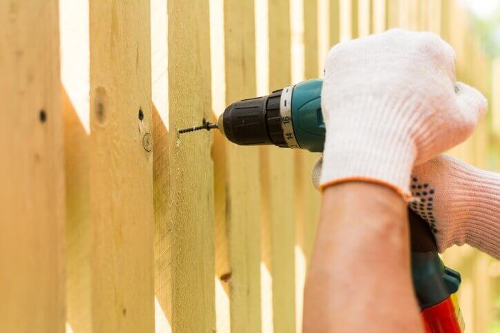 Blue Collar craftsman installing a wood fence